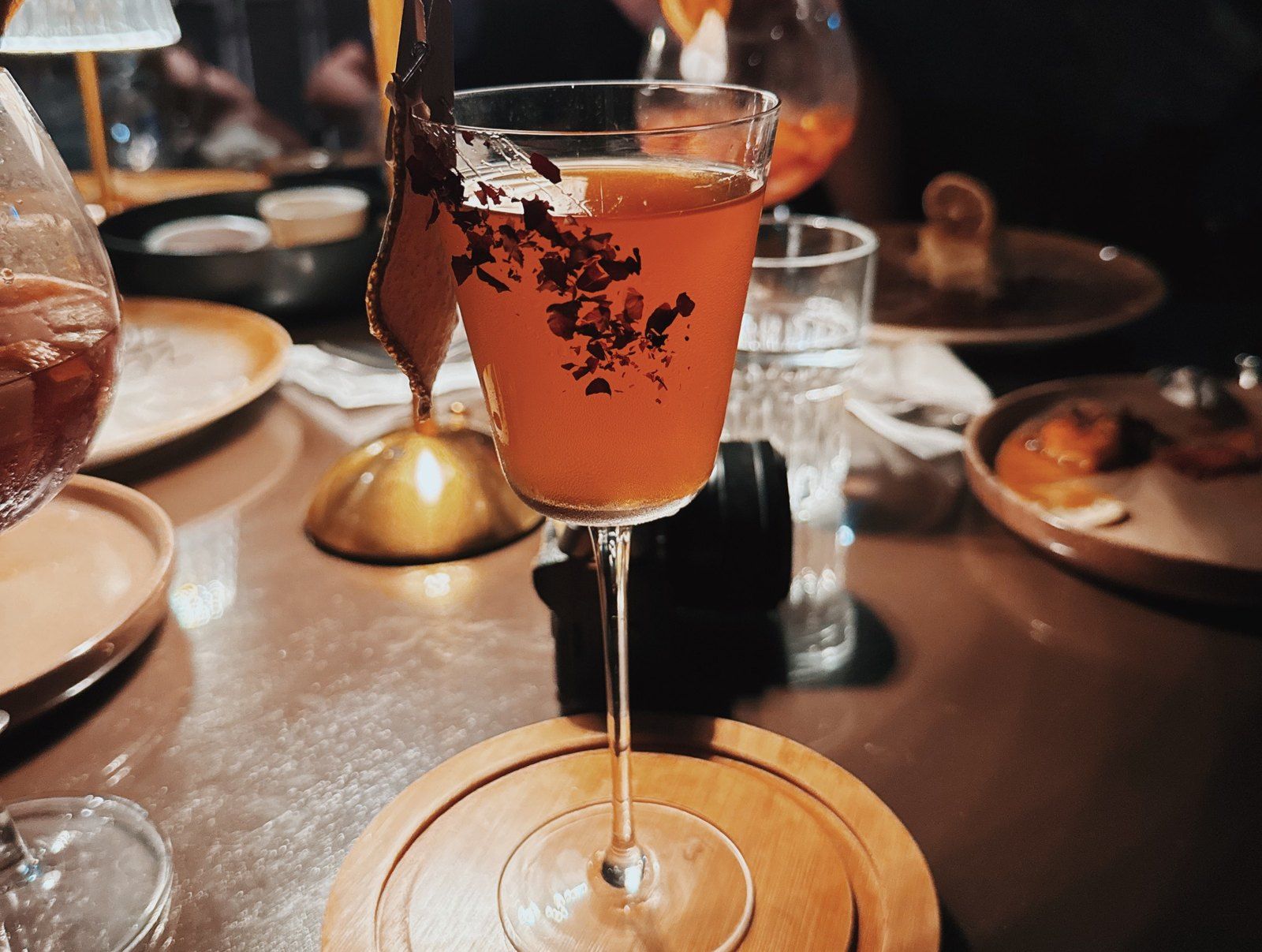 A cocktail in a coupe glass with dried flowers