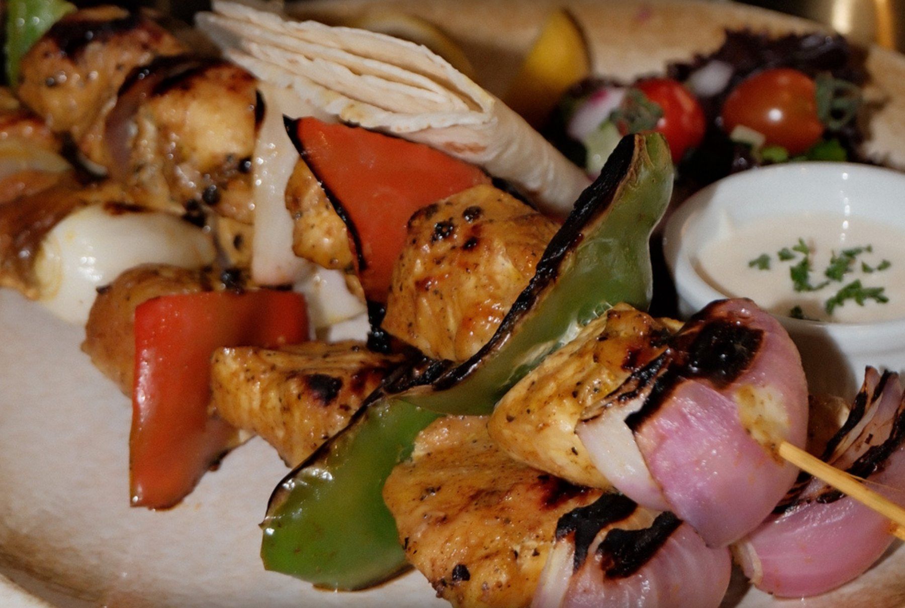 Flame grilled chicken skewers with peppers and onions
