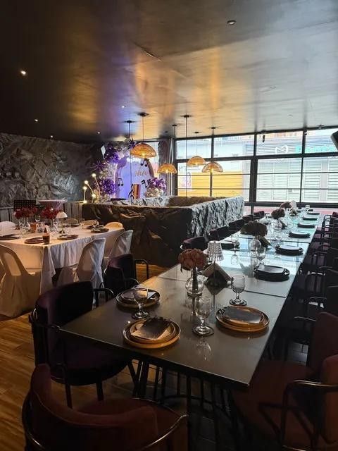 Long tables set for a private party, with a balloon backdrop at the end of the room